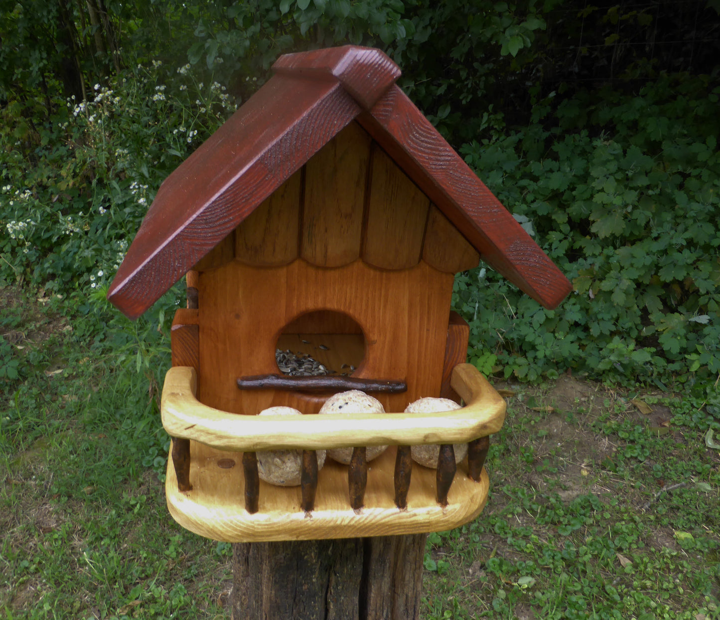 Vogelfutterhaus mit rotem  Dach und   Meisenknödelhalter