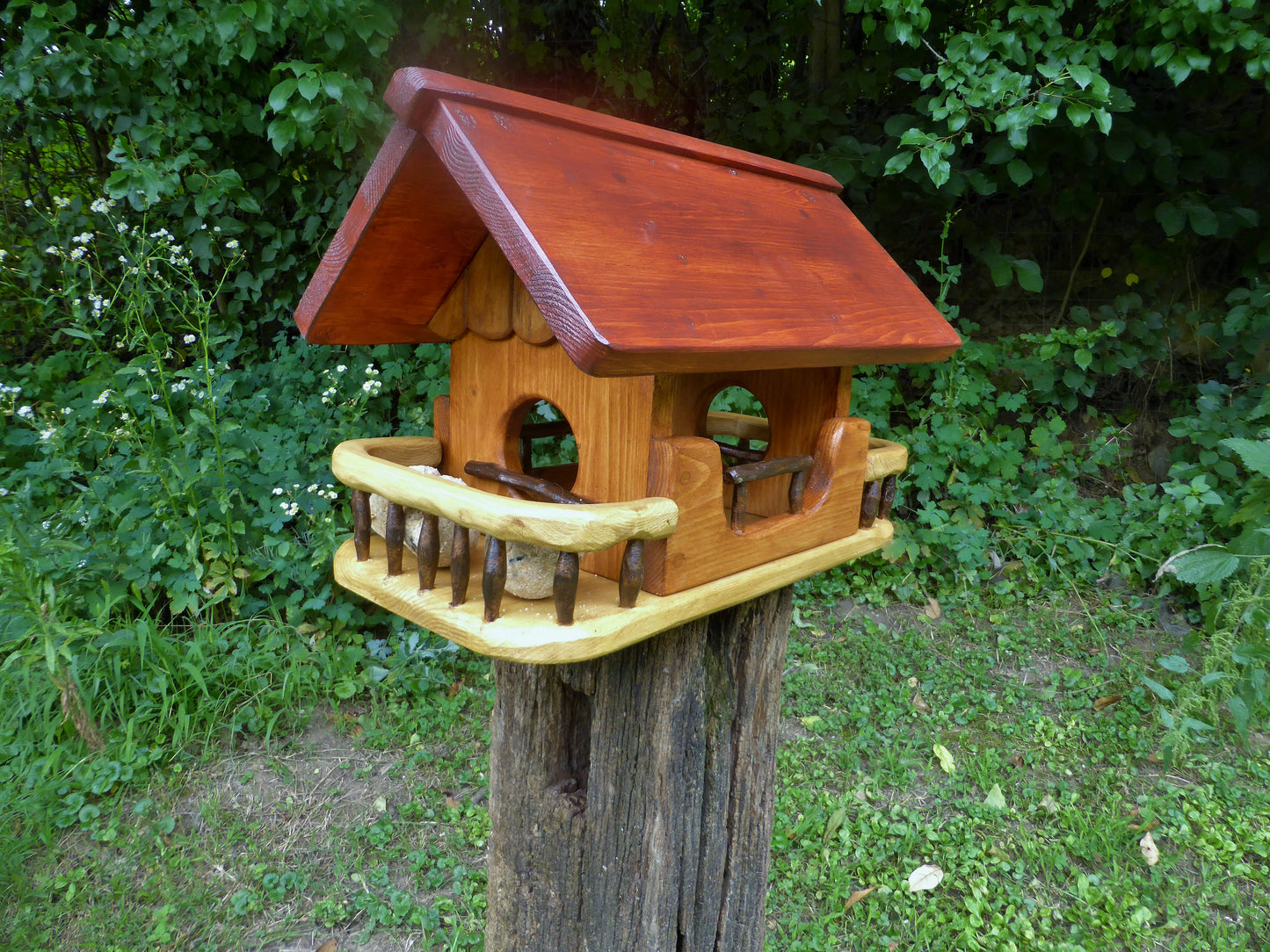 Vogelfutterhaus mit rotem  Dach und   Meisenknödelhalter