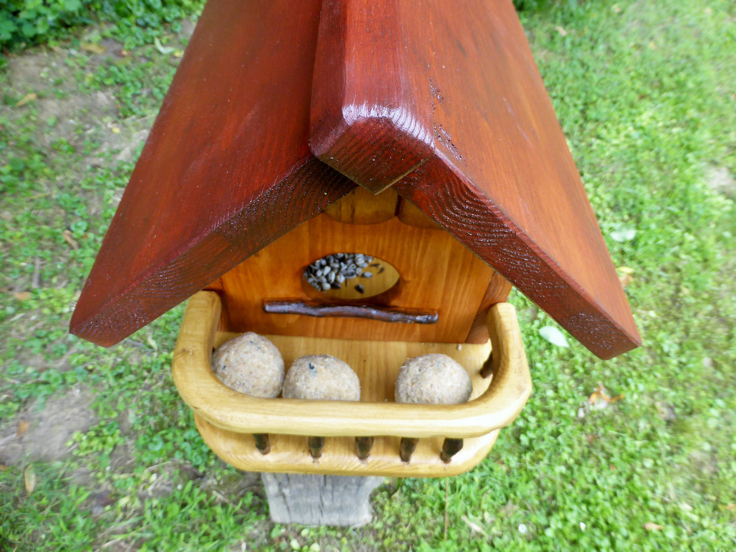 Vogelfutterhaus mit rotem  Dach und   Meisenknödelhalter