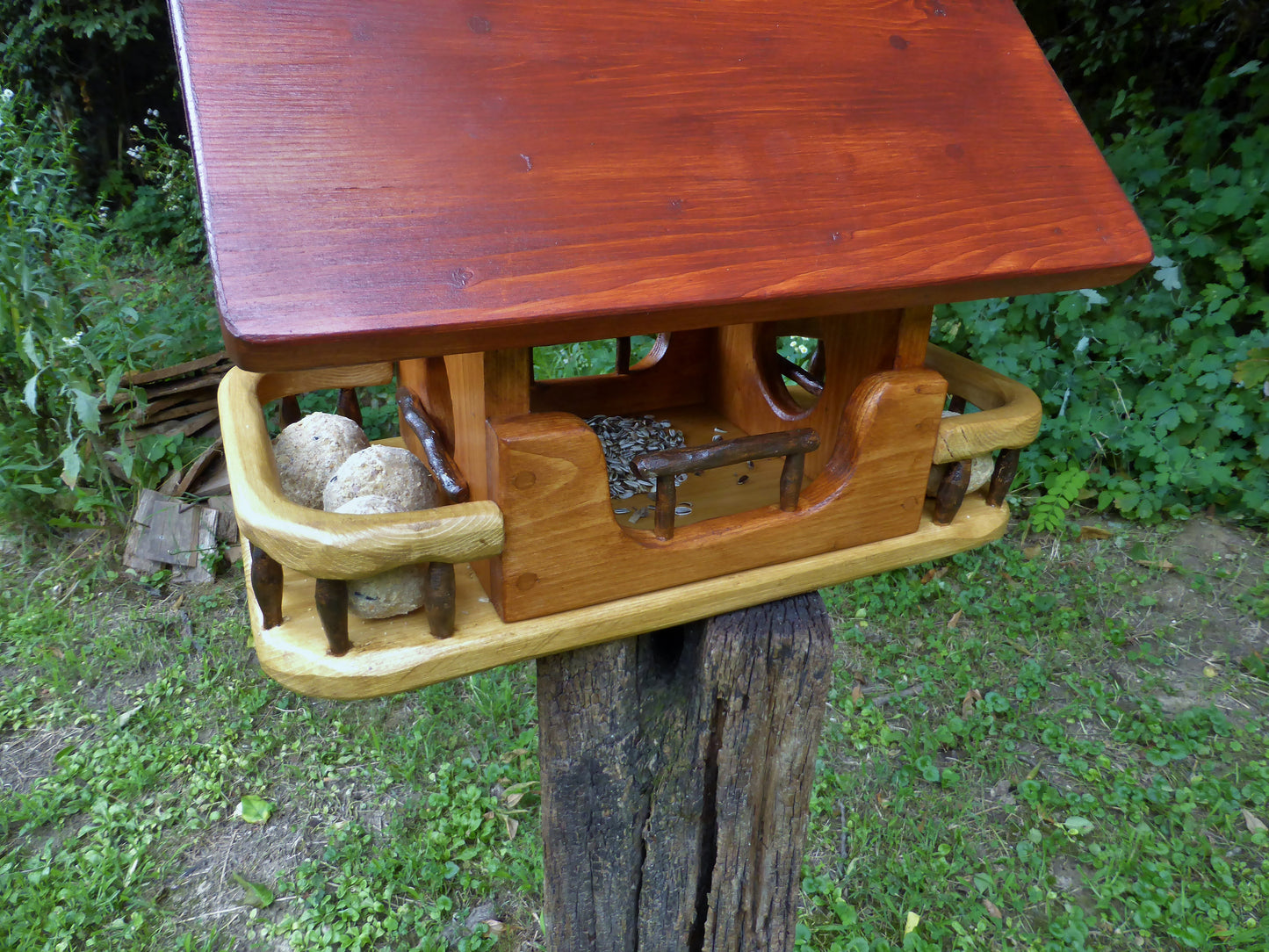 Vogelfutterhaus mit rotem  Dach und   Meisenknödelhalter