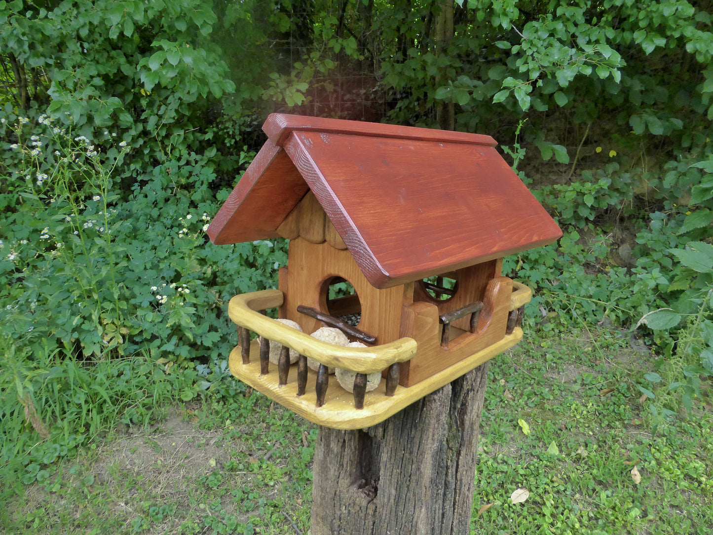 Vogelfutterhaus mit rotem  Dach und   Meisenknödelhalter